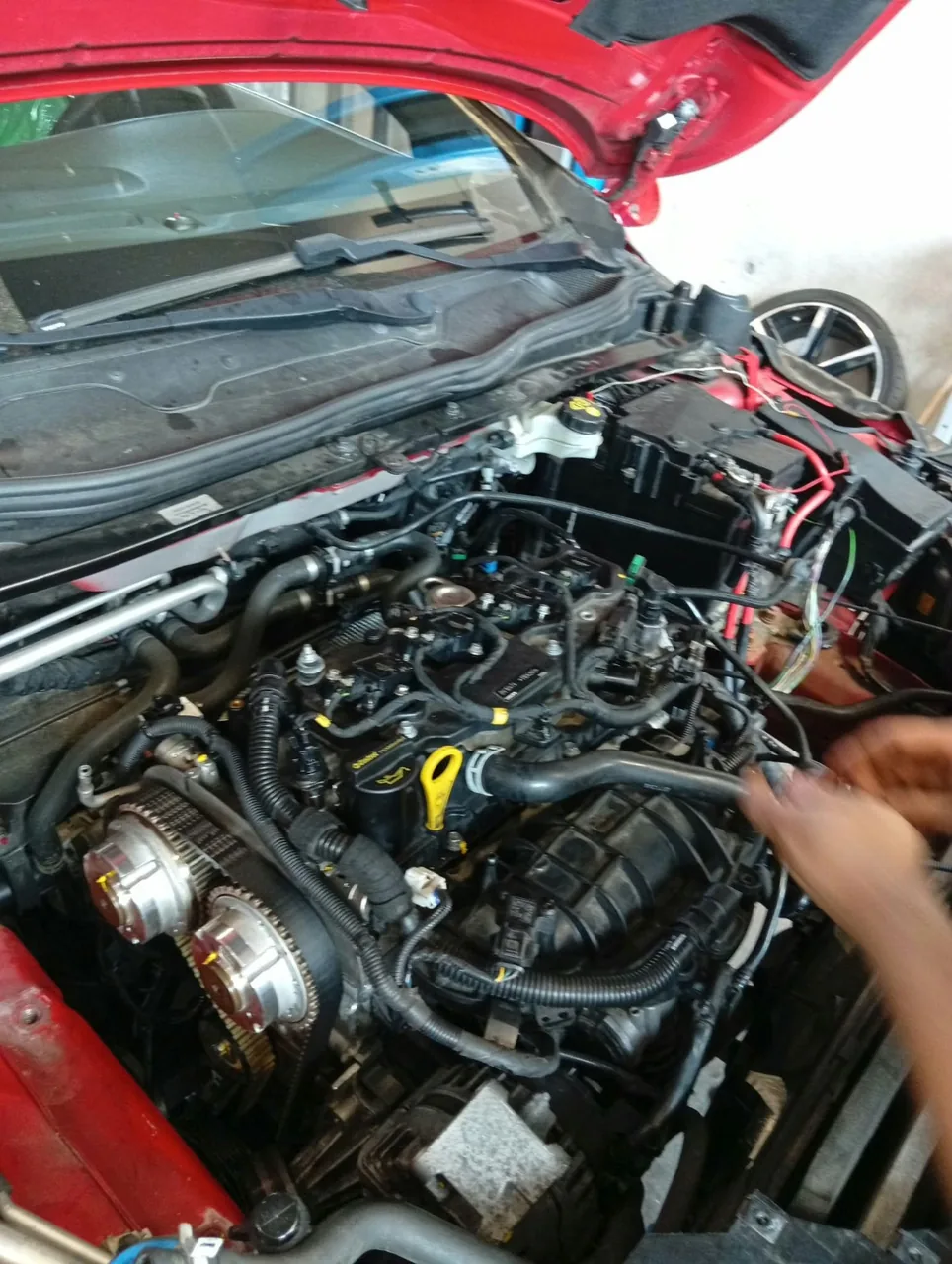 Rot lackiertes Fahrzeug mit geöffneter Motorhaube und freiliegenden Bauteilen