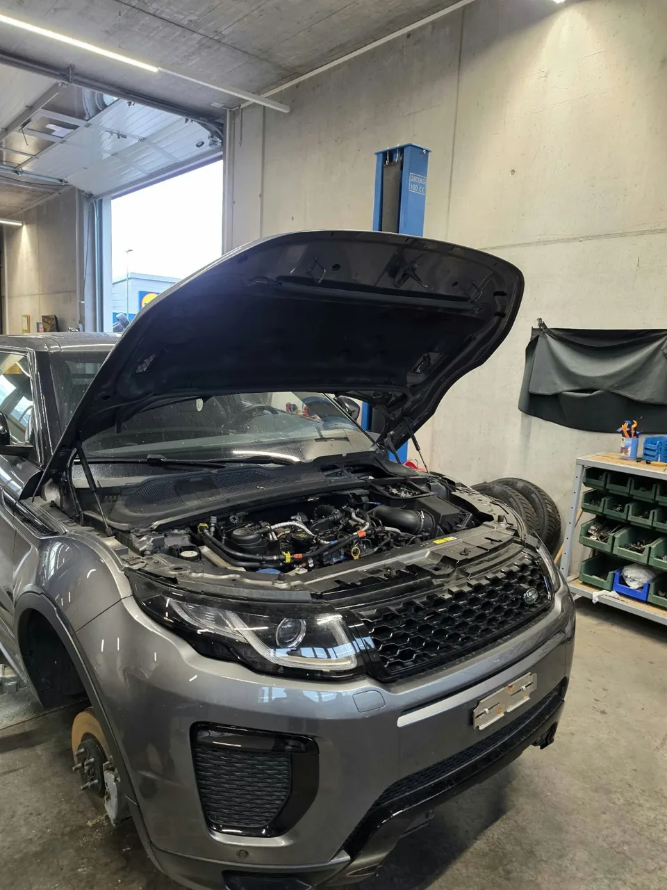 SUV mit geöffneter Motorhaube in der Werkstatt